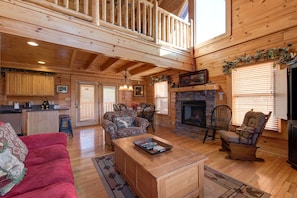 Rustic refinement - With its high vaulted ceiling, stone-surround fireplace, and generous seating, the wood-clad living room is an inviting spot to watch TV, take advantage of the free WiFi, or curl up with a book.