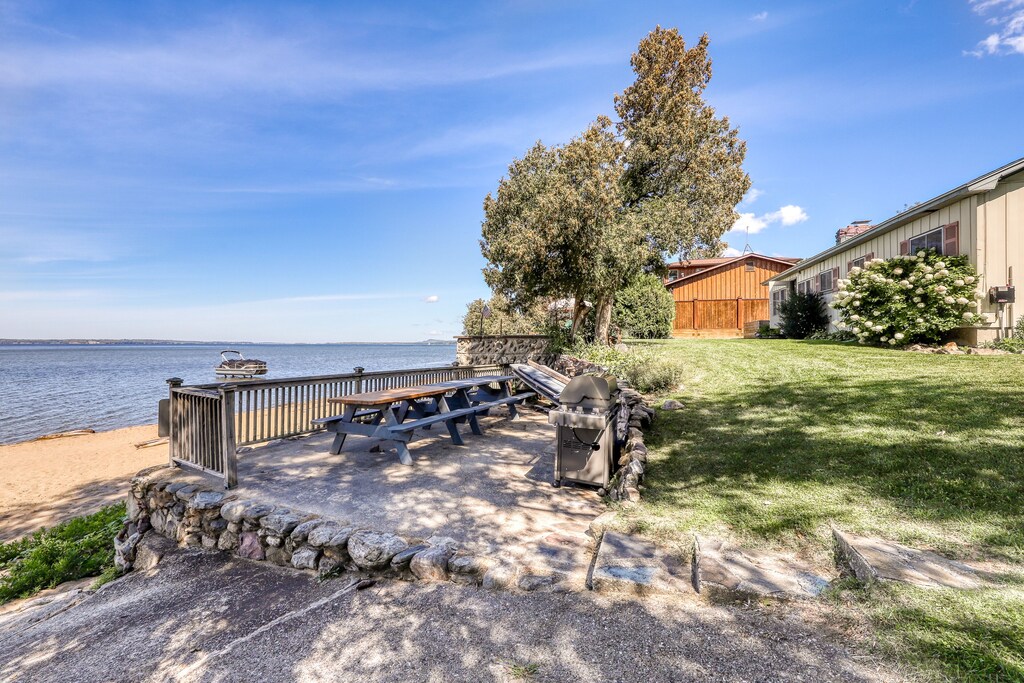 A summer's day at a private beach by a Lake Champlain rental home has a picnic table and grill