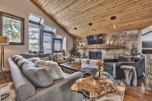 Upper Level Living Room with Cozy Mountain Contemporary Furnishings, a Smart TV and a Gas Assist Wood Fireplace