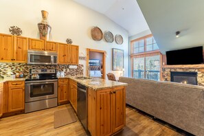 Full size kitchen with stainless steel appliances and granite countertops.