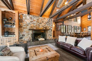 The sunken living room features a flat-screen TV and a wood-burning fireplace.