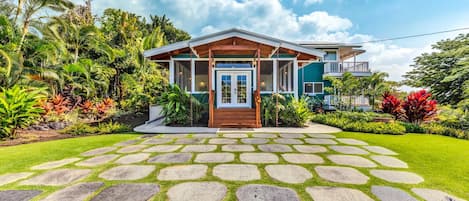 The front yard and exterior of this Kona Hawai'i vacation rental, with stone walkway.