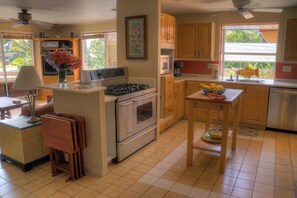 A fully equipped kitchen with corian tops and island cutting board provide ample space to create your gourmet meals