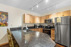 Full kitchen featuring granite countertops and stainless steel appliances.