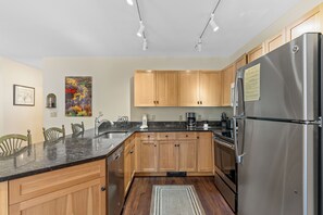 Full kitchen featuring granite countertops and stainless steel appliances.