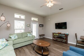 Spacious living area with comfy furnishings and flat screen TV