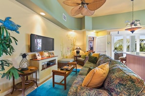 Angled photo of the Living Area with couch in front of the wall-mounted TV.