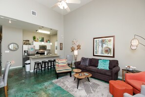 Open-concept living area with high ceilings, flooded with natural light