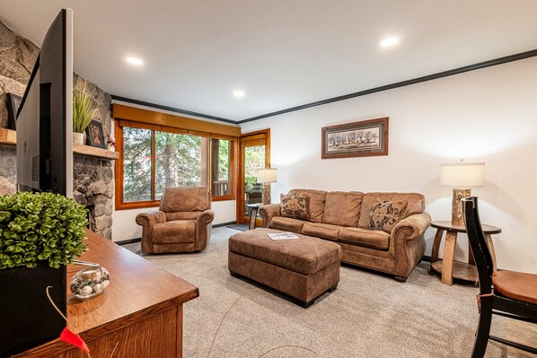 Living Room with Large Flat Screen TV, Gas Fireplace, and Patio Access