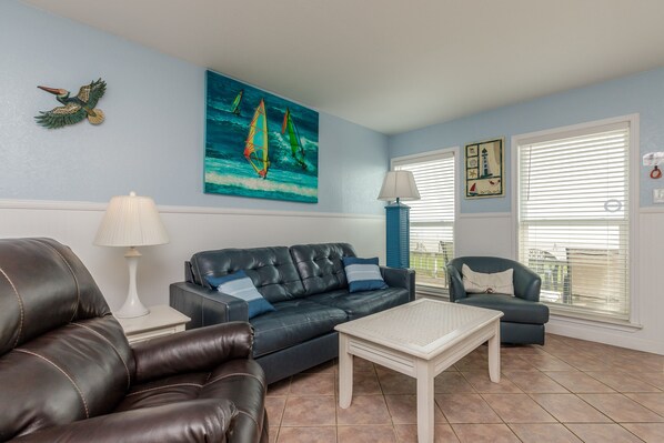 Newly updated living area with queen size sleeper sofa and large windows to view the beautiful beach