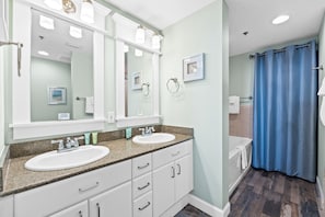 Primary bathroom with double vanity sink, garden tub, & stand-up shower