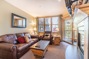 Living area with flat screen TV, gas fireplace and access to the private balcony.