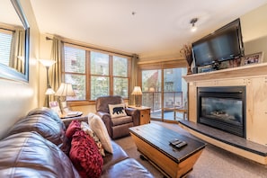 Living area with flat screen TV, gas fireplace and access to the private balcony.
