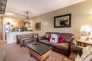 Living area with flat screen TV, gas fireplace and access to the private balcony.