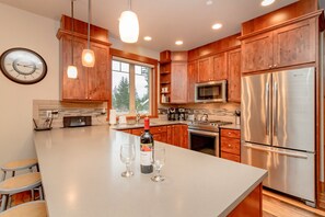 Icing on the Cake - Suncadia Resort - Chef's kitchen with a large bar and stainless appliances.