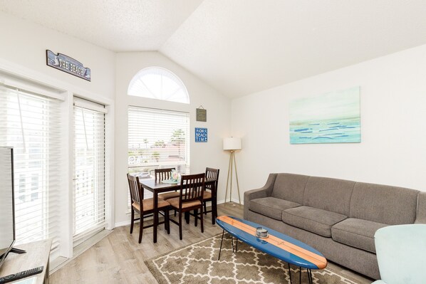 Spacious living with new dining chairs and natural light shining in