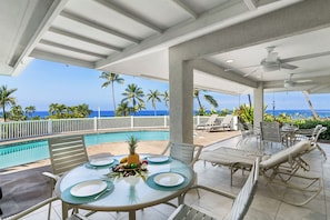 Large covered lanai with ample seating and lounging furniture, ideal for outdoor meals or relaxing any time of day.