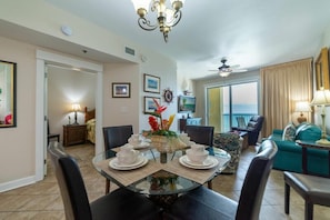 4 are seated comfortably at the dining room table with additional seating at the bar