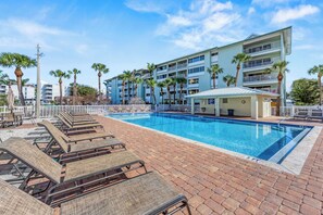 The community pool surrounded with chaise lounges.