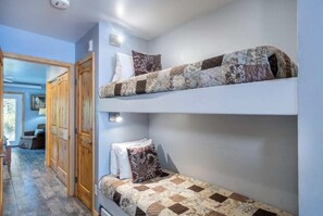 The bunk beds are in between the queen bedroom and the kitchen/living area. Please note, these are small bunk beds, so really only good for kids!