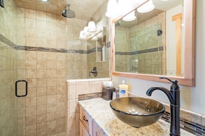 The bathroom features a spacious shower, large vanity area and toilet.