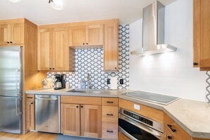 The kitchen features custom cabinetry, stainless appliances & a concrete countertop. It is also fully equipped with all of the basics supplies for your stay!