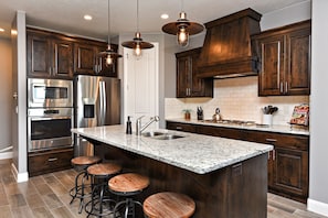 Kitchen - Prepare meals for groups of all sizes with spacious countertops, high-quality stainless steel appliances, and all the dishes, cutlery, and baking dishes you will need.