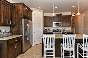 Kitchen View - The kitchen is fully stocked with all the dishes, cookware, baking pans, and cutlery you will need for meal preparations and includes stainless steel appliances and granite counter tops.