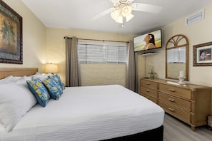 The bedroom offers a queen size bed and wall-mounted TV