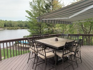 Large patio with table for seating for eight under awning