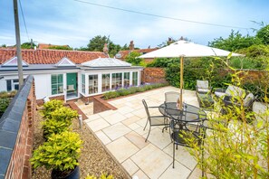 Myrtle Cottage, Friston: The rear terraced garden with outdoor furniture