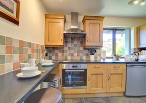 Well fitted kitchen with breakfast bar and two stools