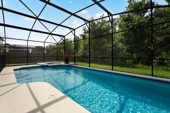 Private oasis swimming pool and spa overlooking a wooded view