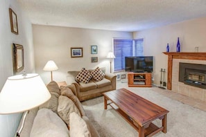 Living room w/ TV and wood burning fireplace