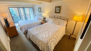 Primary bedroom with 2 Queen beds and a balcony with views to Vail Mountain.