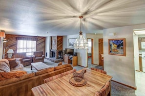 Living room w/ sofa sleeper, wood burning fireplace, and TV