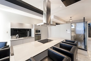Fully equipped kitchen, island with cooking top.