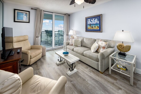 Living room sofa bed and 2 recliners - Living Area with sofa bed and Floor to Ceiling Sliding Glass Door to Balcony
