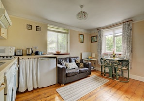 Open plan Living Room with sofa, table and chairs and kitchen area