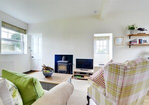 Comfy sofas surround an attractive feature fireplace with wood burning stove
