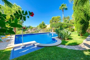 Beautiful garden with green grass around the pool.
