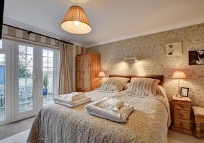 The master bedroom has French doors opening onto a patio with access to the pebbled courtyard