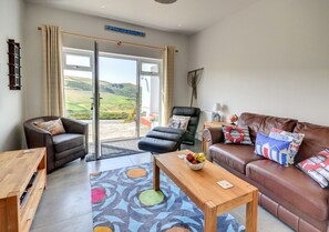 The living room with large French windows offering wonderful country views and sea glimpses 