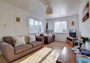 Plenty of comfortable seating in the sitting room, large TV and electric woodburner effect fire