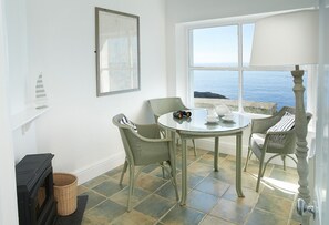 The observation room, a few steps away with an electric wood burning stove effect fire and sitting area. Large windows overlook spectacular sea views