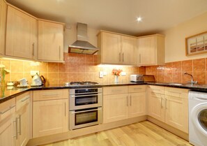 Maple units and granite style work surfaces complement the kitchen and dining areas to the rear