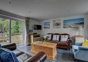 The lovely sitting room overlooks the garden with patio doors leading out onto the patio