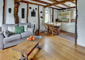 A spacious open plan living room has a dining area and attractive cottage style kitchen to one end