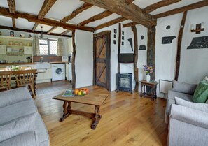 A spacious open plan living room has a dining area and attractive cottage style kitchen to one end