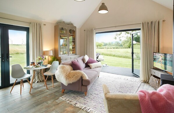 Ground floor: Open-plan kitchen/dining/living area with bi-fold doors opening to private decked area